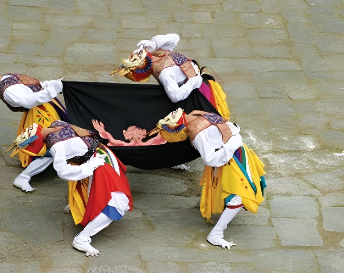 Masked dancers performing a ritual dance on ancient stone paving