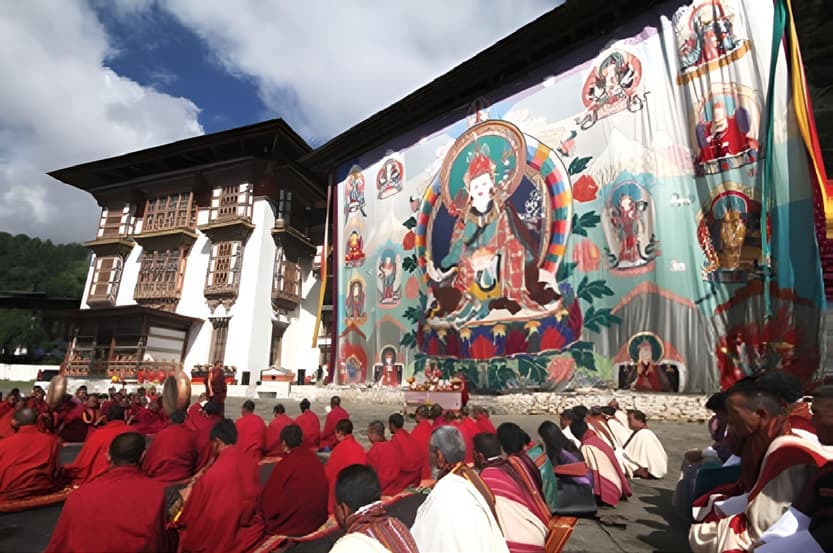 A giant thongdrel thangka unfurled before monks and devotees at a dzong