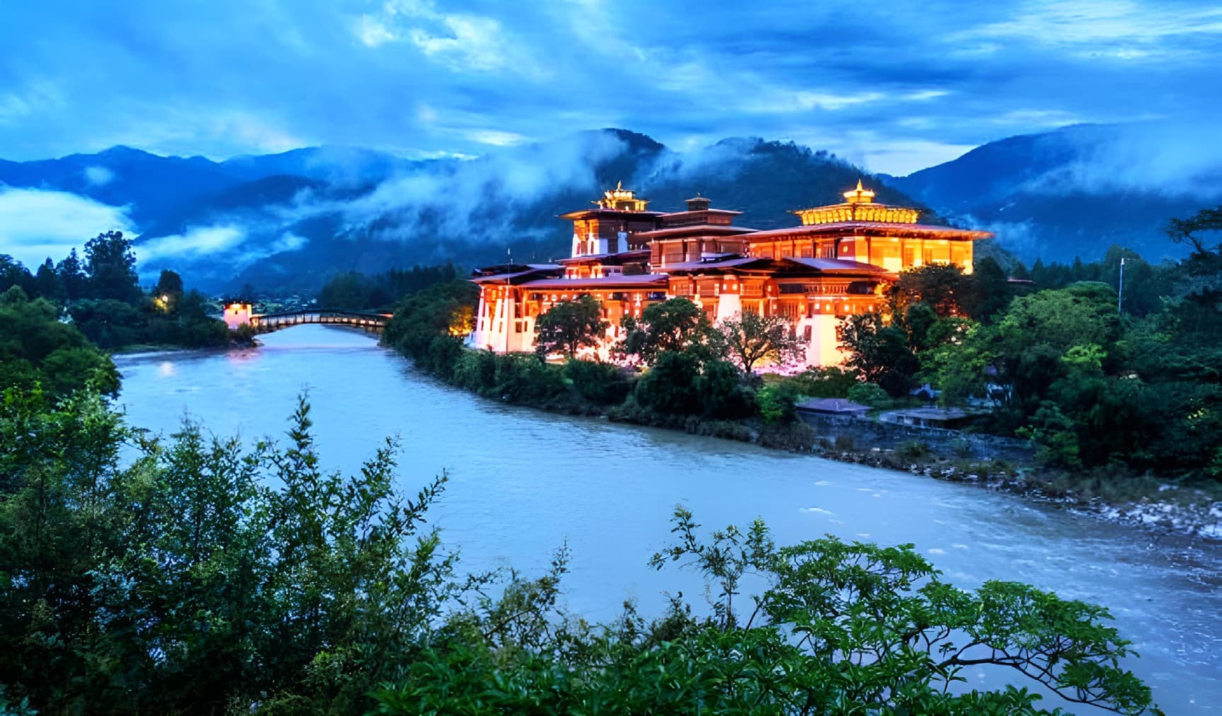 Punakha Dzong lit warmly at dusk beside the river
