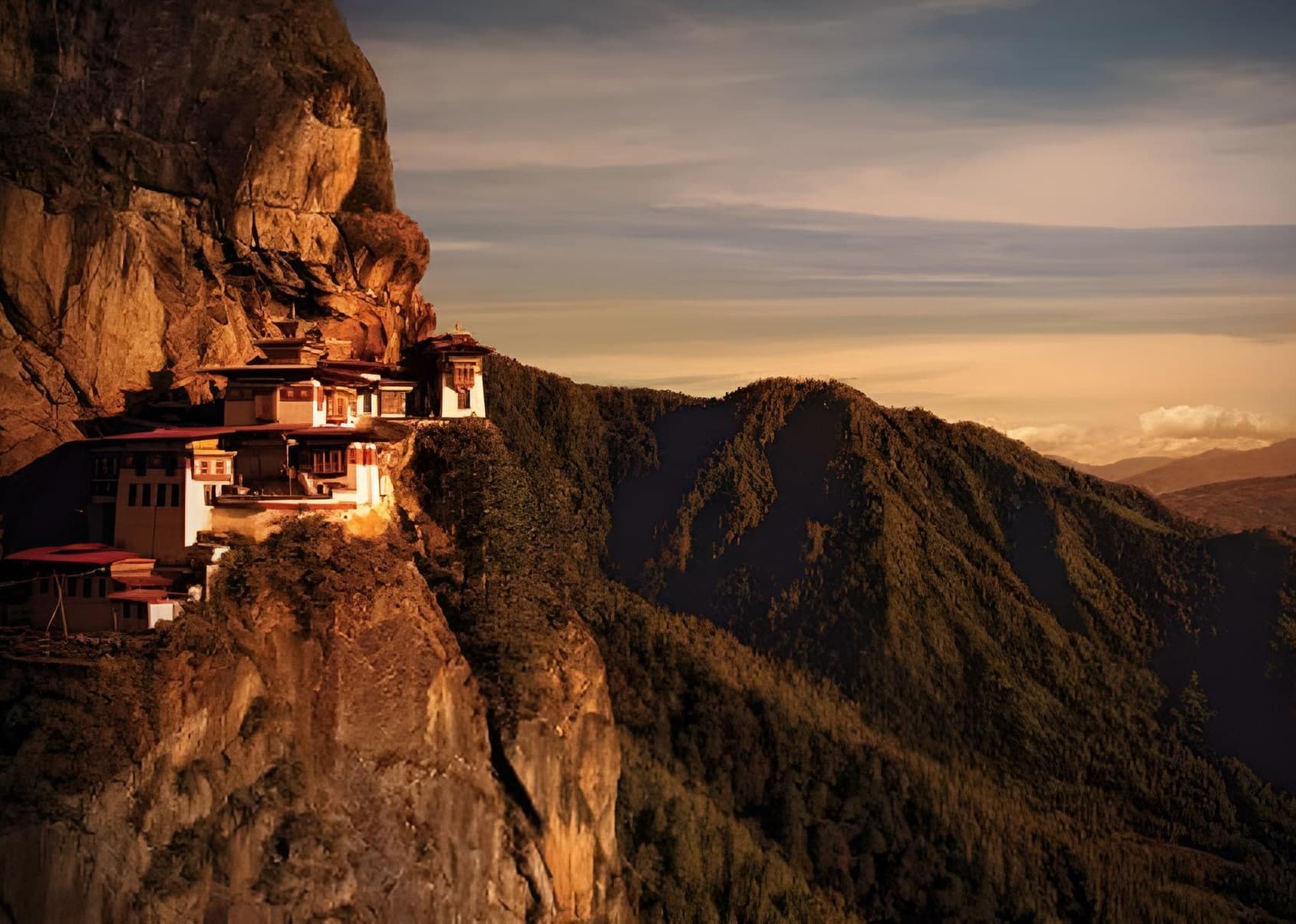 Taktsang Monastery, the Tiger’s Nest, glowing at golden hour on its cliffside above the Paro valley